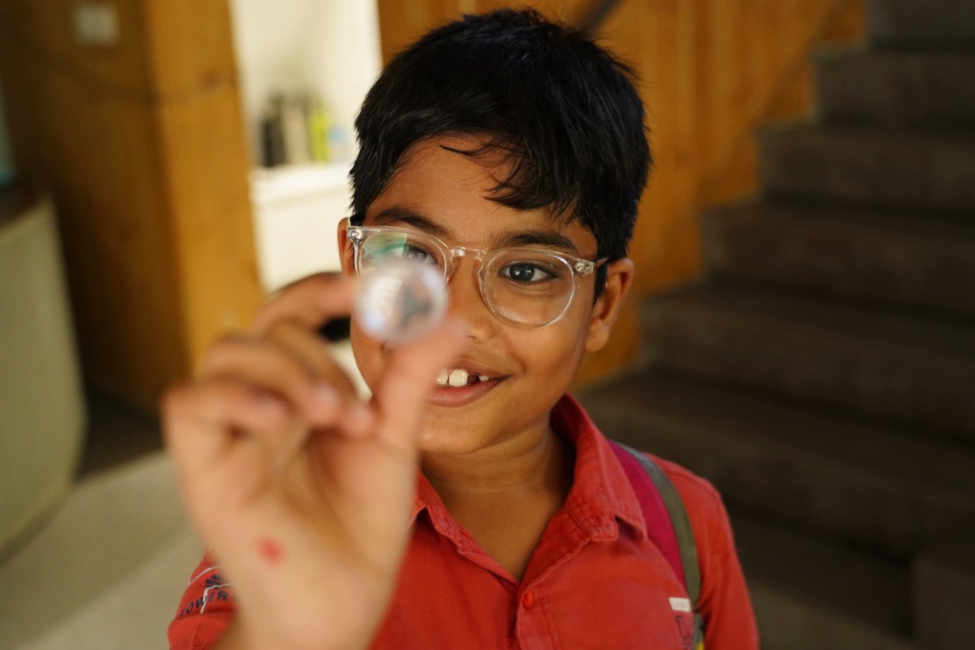 A kid examining a specimen with a magnifying glass