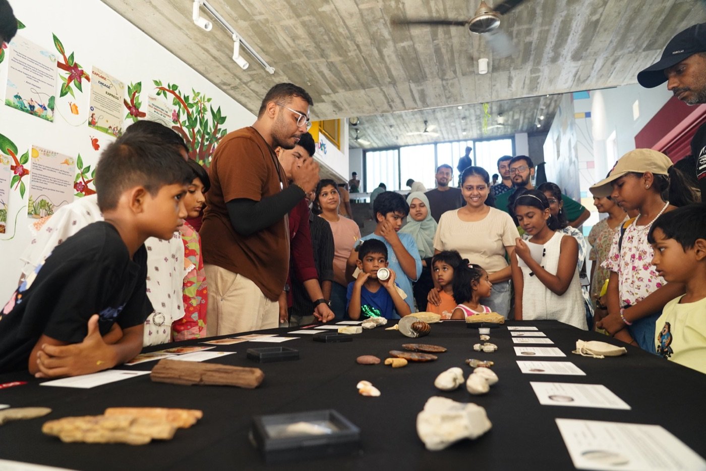 A crowd of kids and adults around the display table